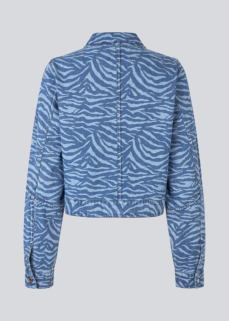 Let cropped jakke i denim. MaseMD print jacket har to brystlommer, skjorte krave og en lynlåslukning fortil. 