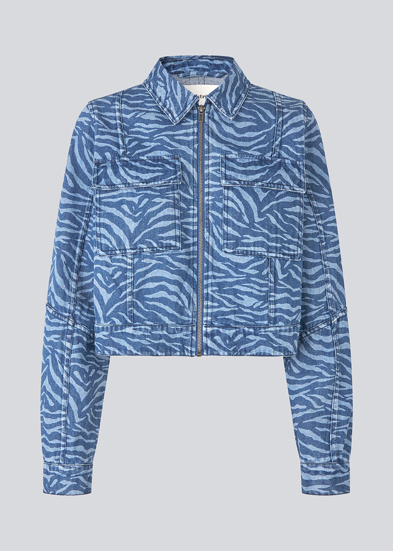 Let cropped jakke i denim. MaseMD print jacket har to brystlommer, skjorte krave og en lynlåslukning fortil. 