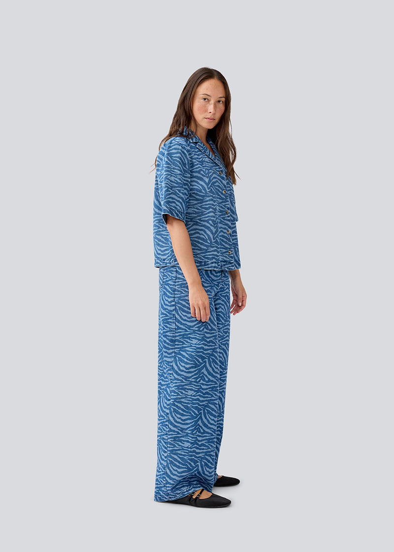 Kortærmet skjorte i Denim i smukt dyre print. MaseMD print SS shirt har en løs pasform, brystlomme og en knappelukning fortil. Modellen er 177 cm og har en str. S/36 på.