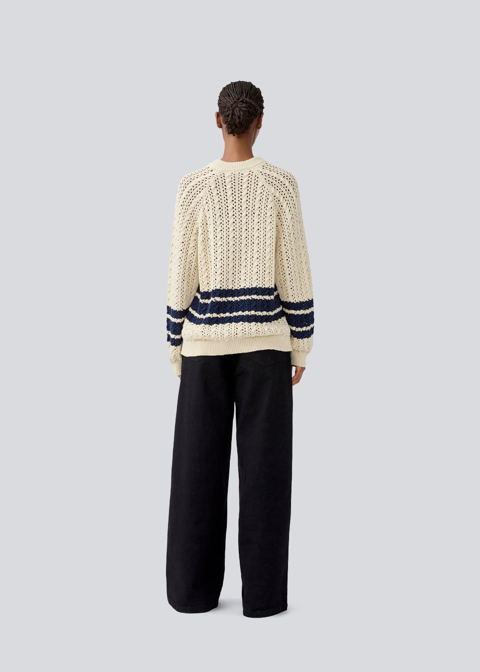 Løs strikket cardigan i beige med mørkeblå striber i kabel strik. MetteMD cardigan er let gennemsigtig, har løse ærmer og en knappelukning fortil. Modellen er 177 cm og har en str. S/36 på.