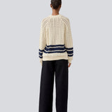 Løs strikket cardigan i beige med mørkeblå striber i kabel strik. MetteMD cardigan er let gennemsigtig, har løse ærmer og en knappelukning fortil. Modellen er 177 cm og har en str. S/36 på.
