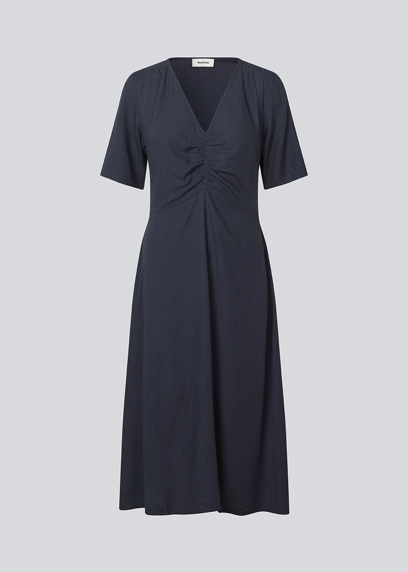 Maxi kjole med korte ærmer og v-hals. MiguelMD SS dress har smock detaljer og en usynlig lynlås i siden.