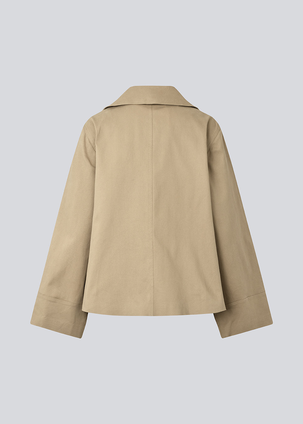 Jakke i beige med asymmetrisk lukning. MillaMD jacket har to lommer fortil, krave og brede ærmer