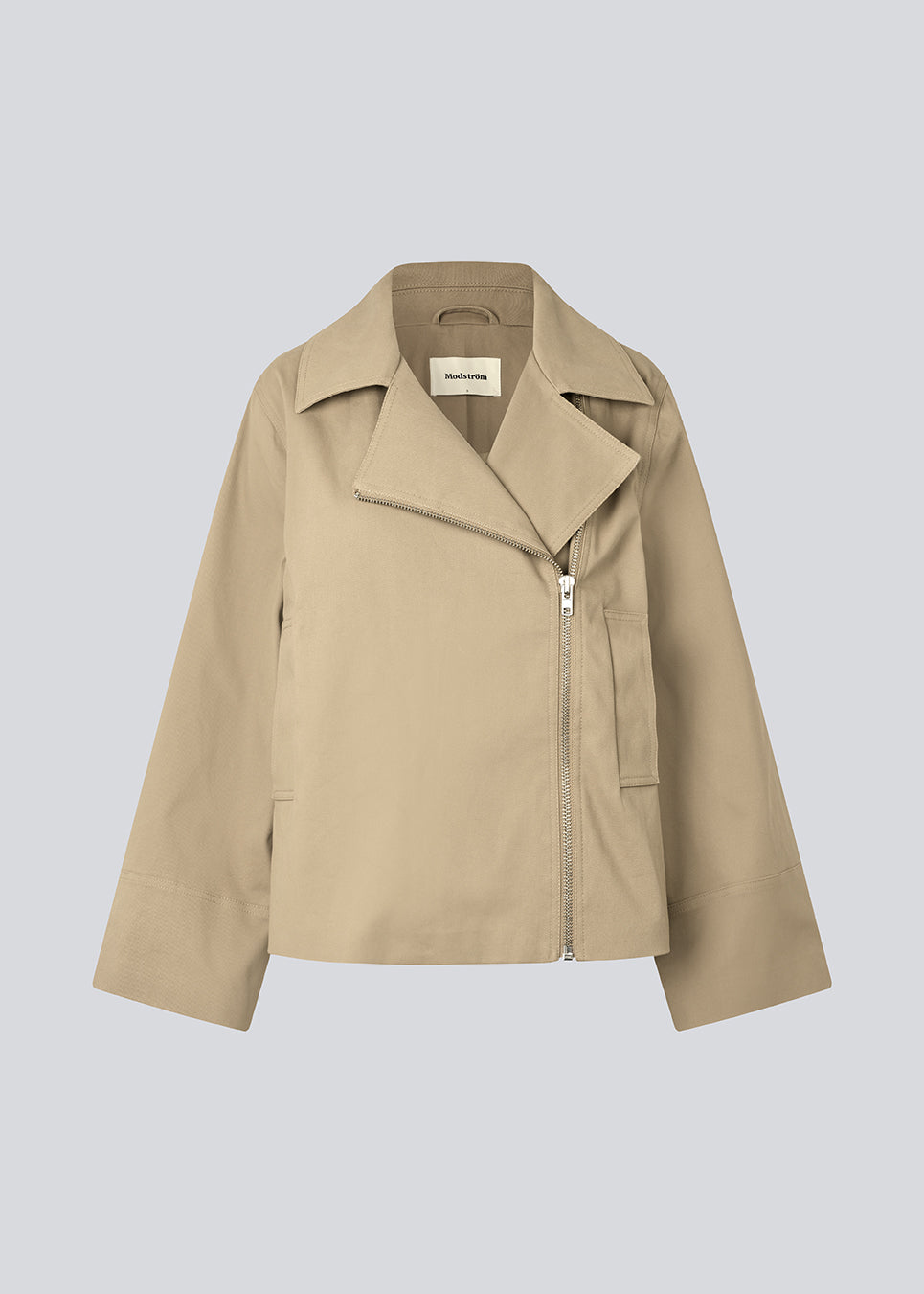 Jakke i beige med asymmetrisk lukning. MillaMD jacket har to lommer fortil, krave og brede ærmer