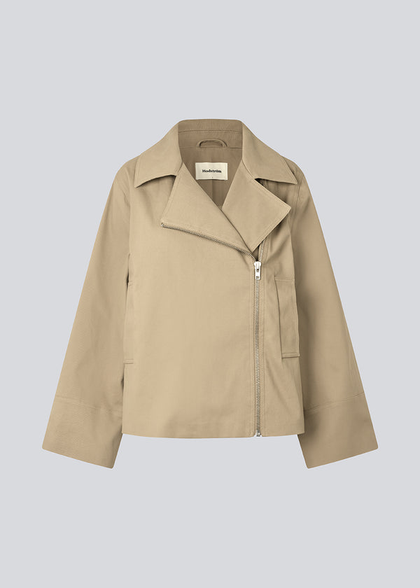 Jakke i beige med asymmetrisk lukning. MillaMD jacket har to lommer fortil, krave og brede ærmer
