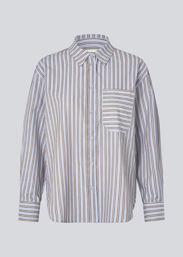Klassisk skjorte i farven Blue Bell Stripe med åbning i ryggen og sløjfe detaljer. Millemd shirt har en oversize pasform og manchet med knappelukning.