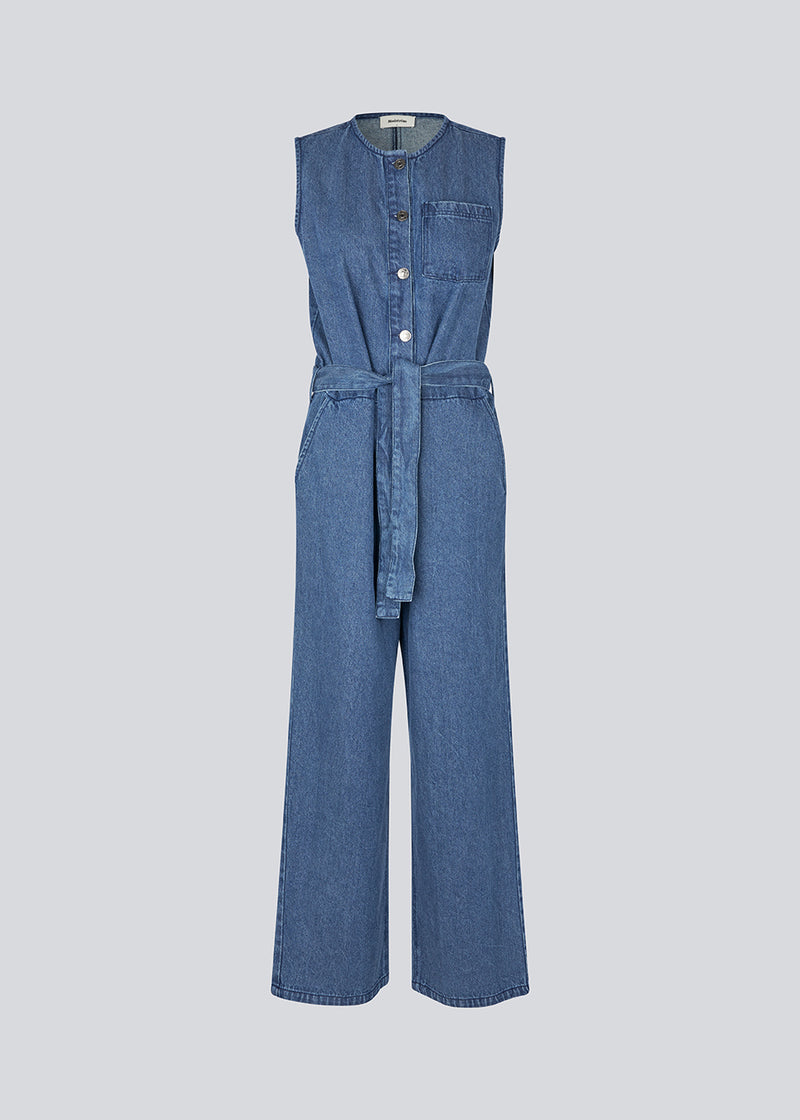 Ærmeløs jumpsuit med bindebånd i denim. MinniMD jumpsuit har lange vide ben, sidde lommer og en knappelukning fortil.