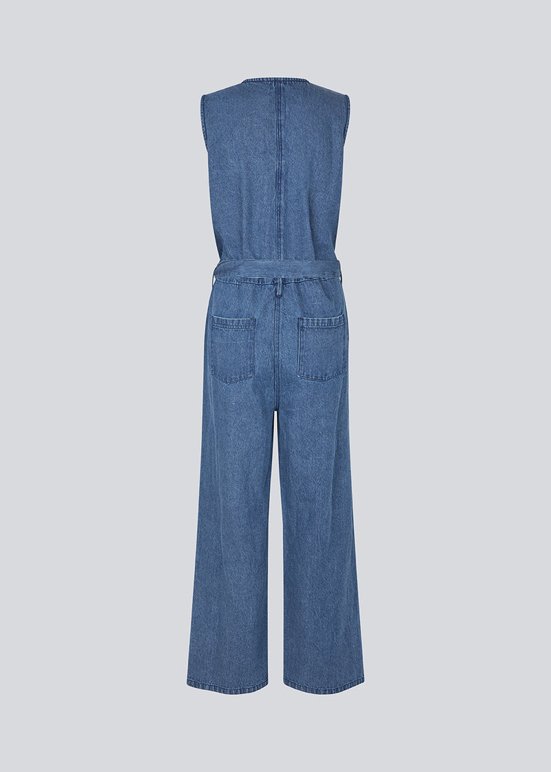 Ærmeløs jumpsuit med bindebånd i denim. MinniMD jumpsuit har lange vide ben, sidde lommer og en knappelukning fortil.