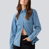 Blød denim skjorte i 100% bomuldsdenim. MinniMD shirt er figursyet og har en knappelukning fortil og skjortekrave.