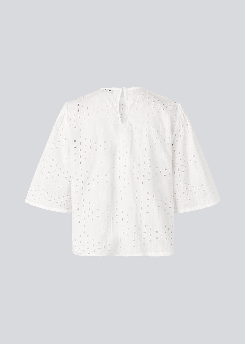 Top med korte ærmer i broderie anglaise. MisoMD top har en løs pasform og en slids med knappelukning i ryggen. 