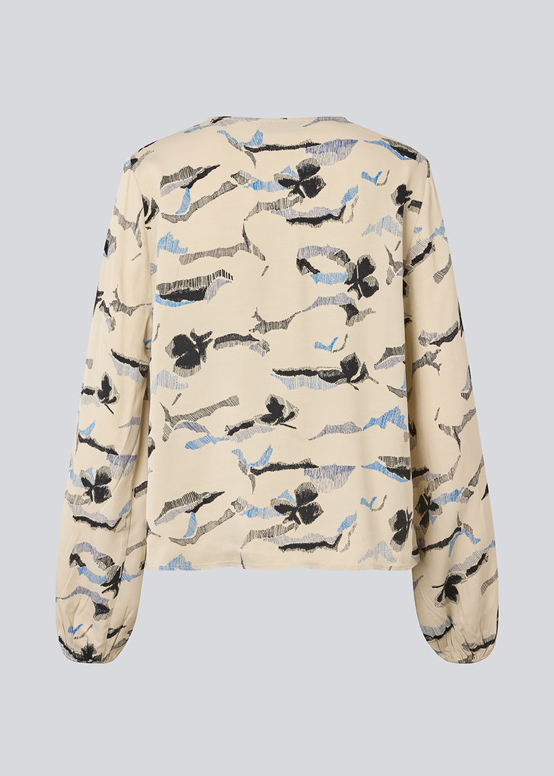 Bluse med v-udskæring og løse ærmer. MistMD print top har en løs pasform og knappelukning med beklædte knapper fortil.