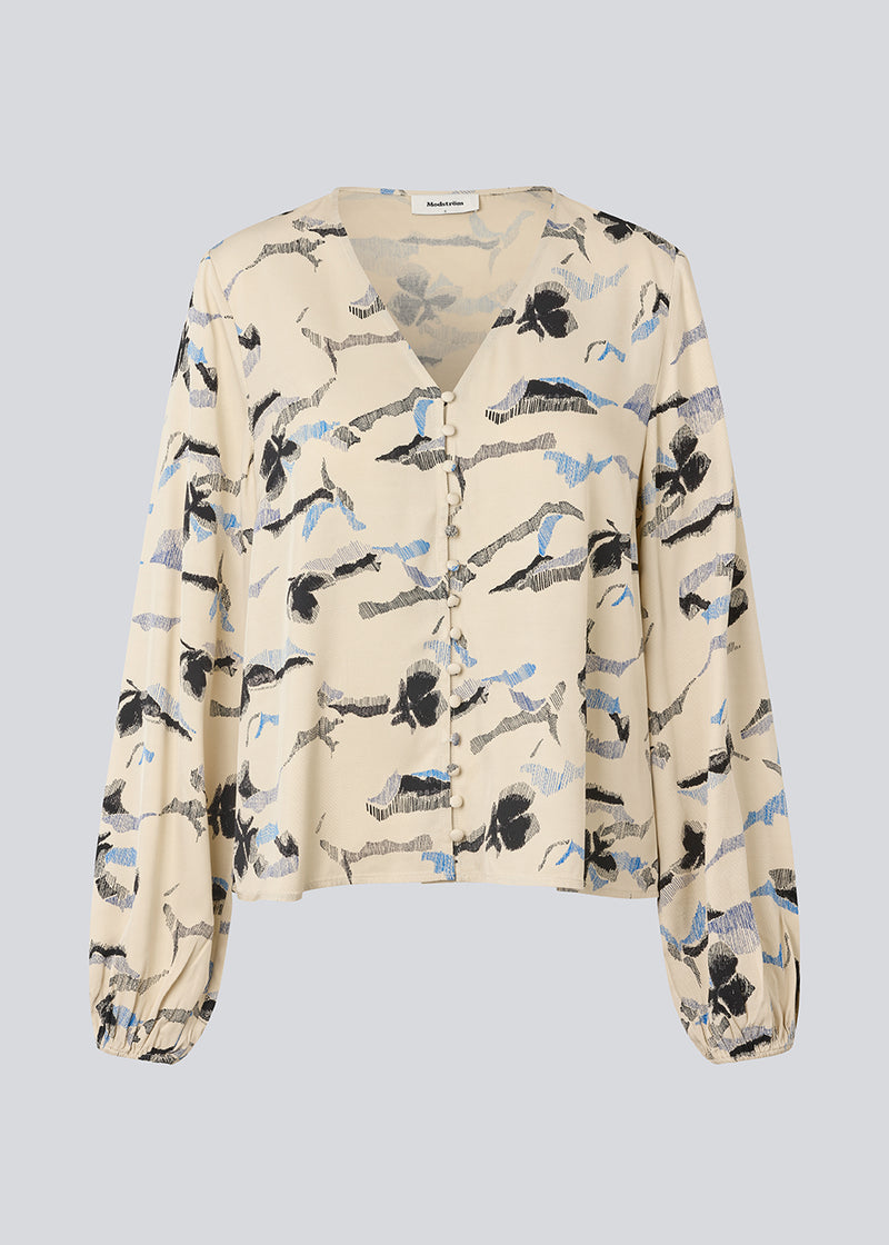 Bluse med v-udskæring og løse ærmer. MistMD print top har en løs pasform og knappelukning med beklædte knapper fortil.