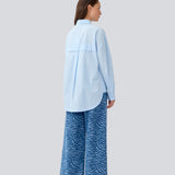 Blå klassisk skjorte med en oversize pasform. MyraMD shirt har en skjult knappelukning fortil og en slids i siden. Modellen er 177 cm og har en str. S/36 på.
