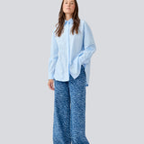 Blå klassisk skjorte med en oversize pasform. MyraMD shirt har en skjult knappelukning fortil og en slids i siden. Modellen er 177 cm og har en str. S/36 på.

