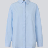 Blå klassisk skjorte med en oversize pasform. MyraMD shirt har en skjult knappelukning fortil og en slids i siden. Modellen er 177 cm og har en str. S/36 på.
