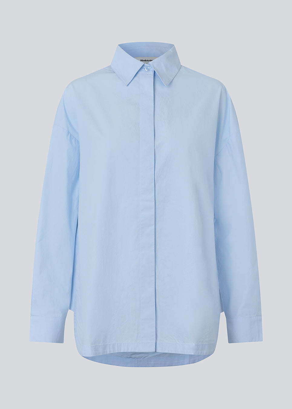 Blå klassisk skjorte med en oversize pasform. MyraMD shirt har en skjult knappelukning fortil og en slids i siden. Modellen er 177 cm og har en str. S/36 på.
