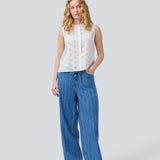 Ærmeløs hvid top i broderie anglaise. NanetteMD top har en høj hals og en knappelukning fortil.
