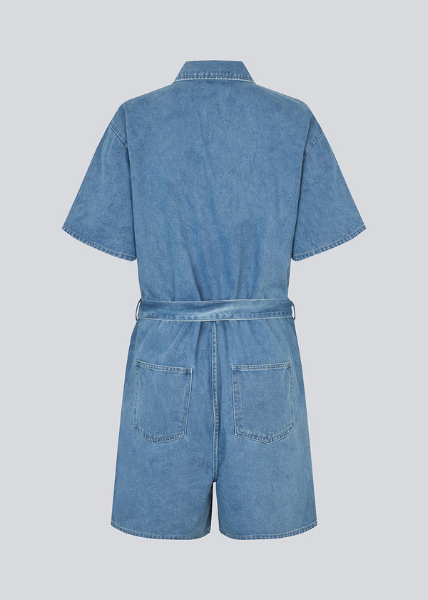 Kort denim playsuit med bindebånd i 100% økologisk bomulds denim. NaomaMD solid playsuit har en knappelukning fortil, skjorte krave og sidelommer.