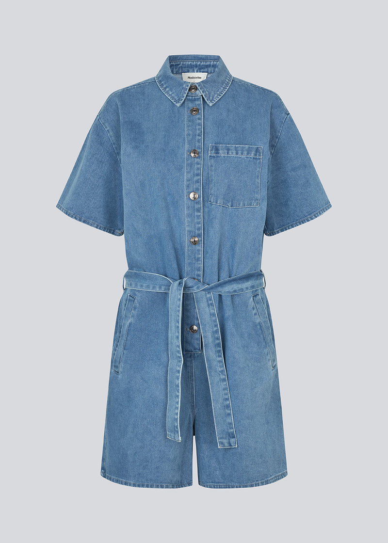 Kort denim playsuit med bindebånd i 100% økologisk bomulds denim. NaomaMD solid playsuit har en knappelukning fortil, skjorte krave og sidelommer.
