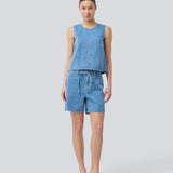 Ærmeløs blå top med rund hals i bomulds denim. NaomaMD solid top har en løs pasform og en åbning i nakken med knappelukning.
