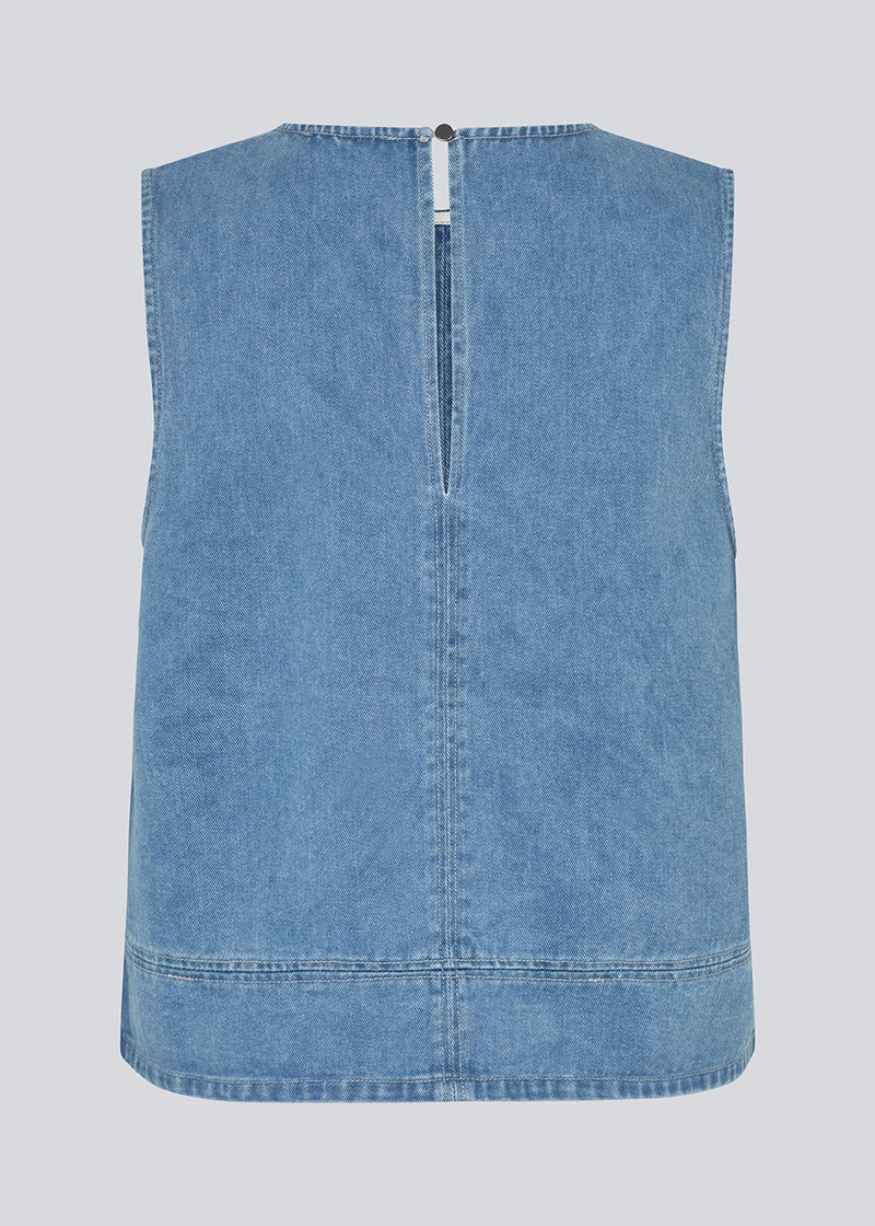 Ærmeløs blå top med rund hals i bomulds denim. NaomaMD solid top har en løs pasform og en åbning i nakken med knappelukning.
