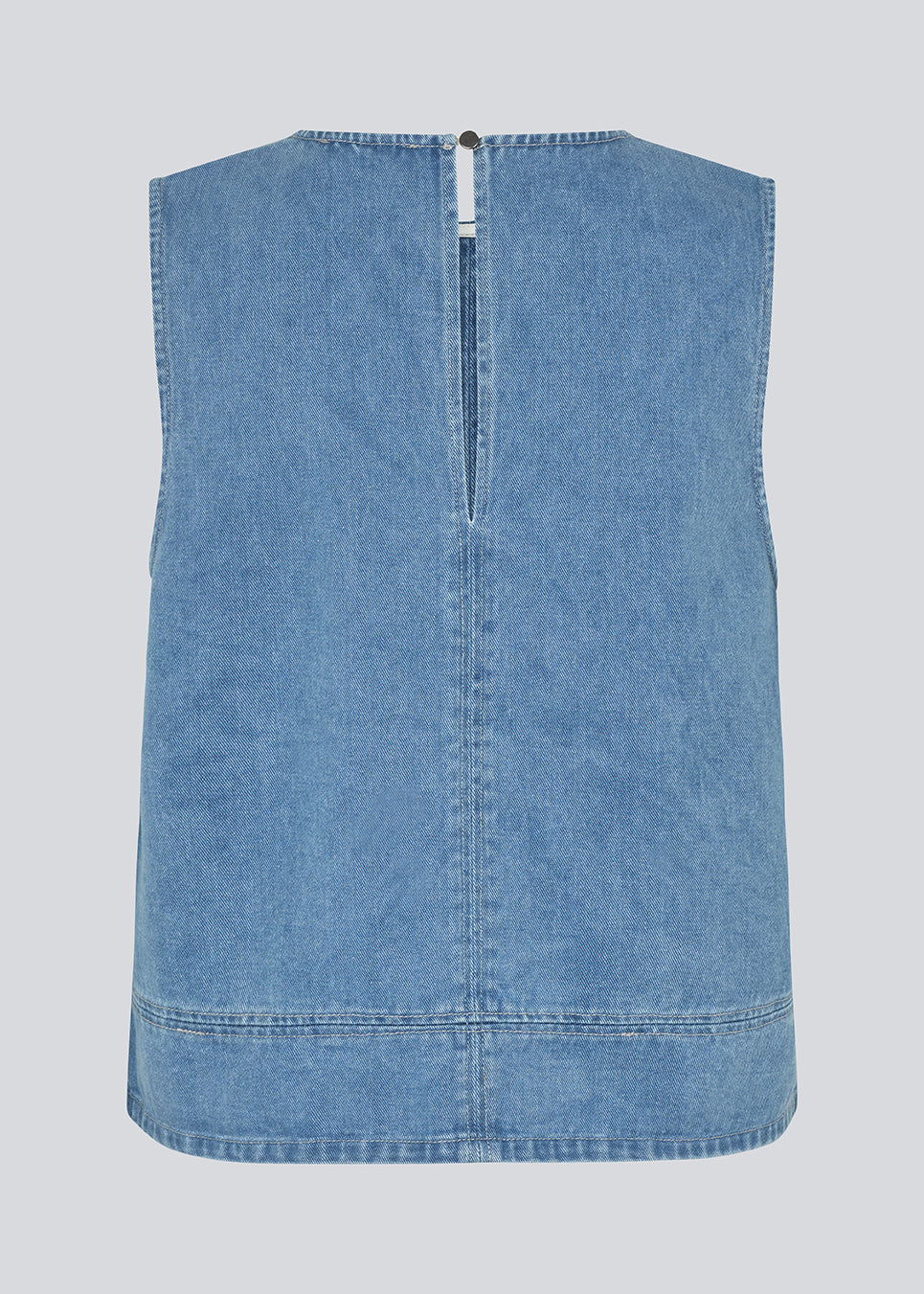 Ærmeløs blå top med rund hals i bomulds denim. NaomaMD solid top har en løs pasform og en åbning i nakken med knappelukning.
