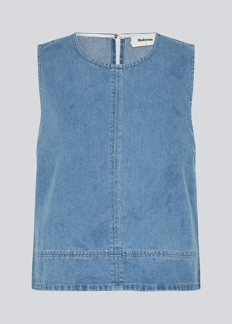 Ærmeløs blå top med rund hals i bomulds denim. NaomaMD solid top har en løs pasform og en åbning i nakken med knappelukning.
