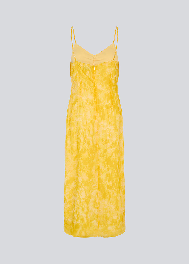 Lang kjole i smuk gul med tynde justerbare stropper og rynkedetalje ved brystet. Napthalimd print strap dress har en slids i front og en usynlig lynlås i ryggen.