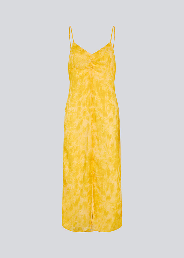 Lang kjole i smuk gul med tynde justerbare stropper og rynkedetalje ved brystet. Napthalimd print strap dress har en slids i front og en usynlig lynlås i ryggen.