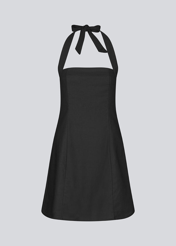 Sort kort halterneck kjole med smockdetaljer på ryggen. NedraMD dress er let figursyet og har en lynlås i siden.