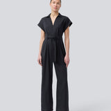 Sort jumpsuit med vidde ben og bindebånd i taljen. NedraMD jumpsuit har en krave, v-hals og lynlåslukning fortil.