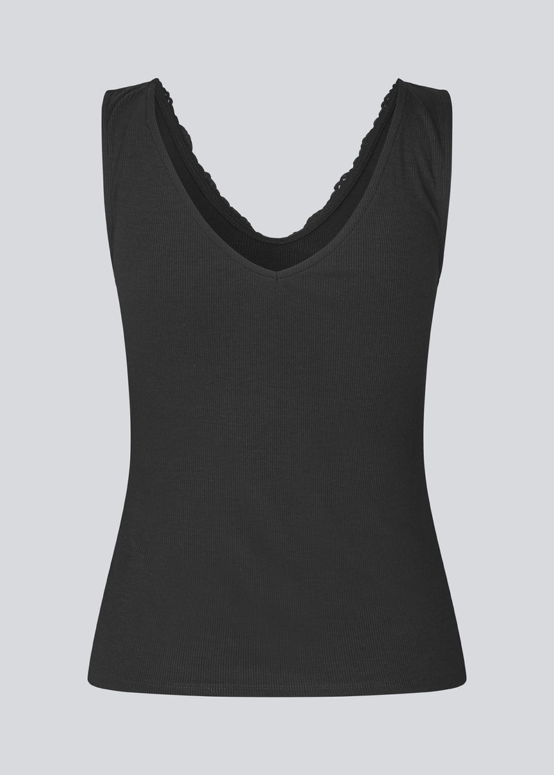 Ærmeløs top med blondekant i ribbed jersey. NemiMD top er figursyet og har en v-udskæring.