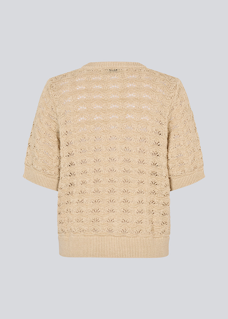 Kortærmet beige cardigan i strik med pointelle mønster. NeppoMD cardigan har en løs pasform og en knappelukning fortil.
