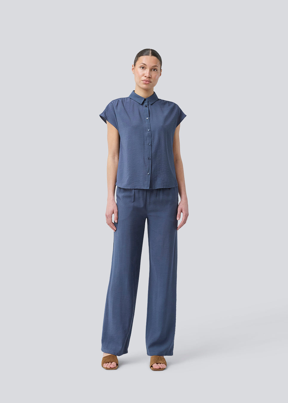 Ærmeløs skjorte i blå med knappelukning fortil i EcoVero viscose. NickiMD SS shirt har en løs pasform en rynkedetalje ved skulderen.