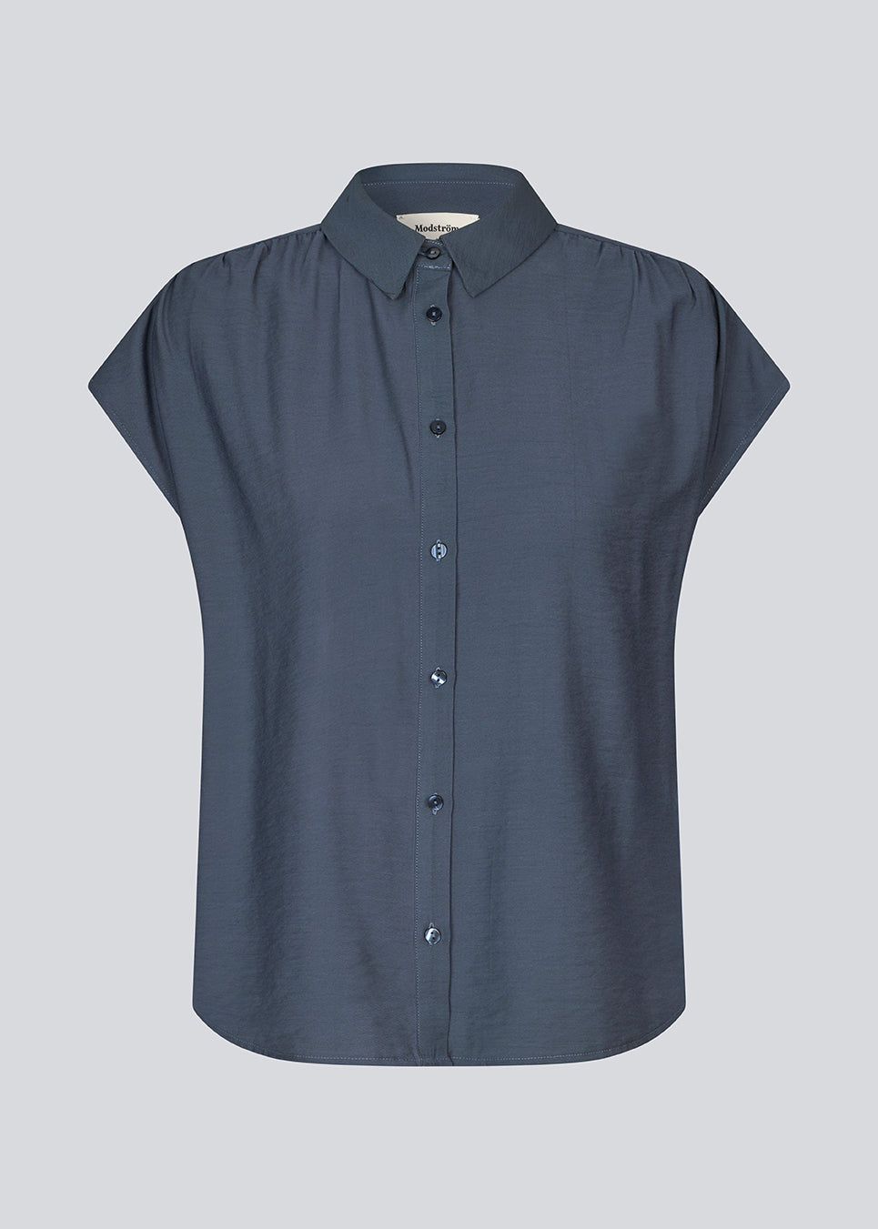 Ærmeløs skjorte i blå med knappelukning fortil i EcoVero viscose. NickiMD SS shirt har en løs pasform en rynkedetalje ved skulderen.