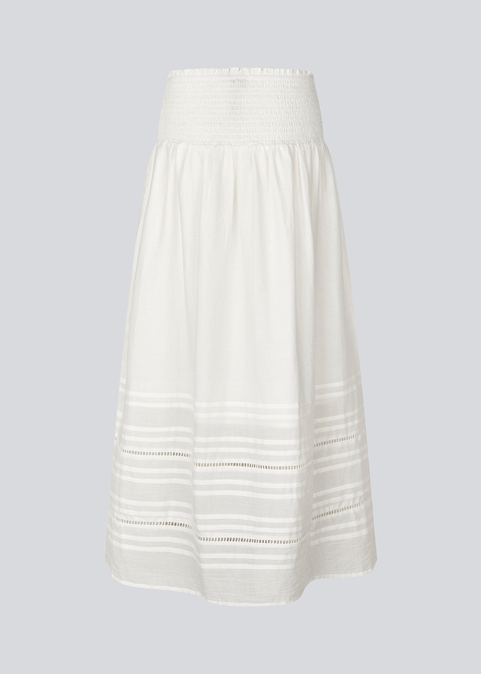 Lang nederdel i hvid i 100% økologisk bomuld. NillaMD skirt har et løst skørt med læg og flæsedetaljer og en elastisk talje med smock.