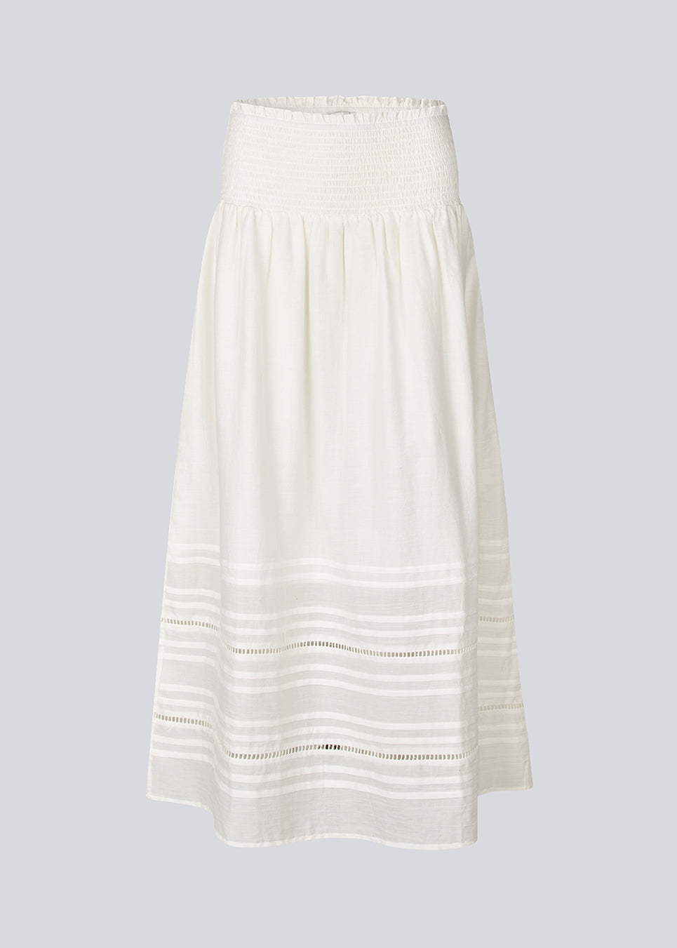 Lang nederdel i hvid i 100% økologisk bomuld. NillaMD skirt har et løst skørt med læg og flæsedetaljer og en elastisk talje med smock.