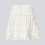 Kort hvid nederdel i 100% økologisk bomuld. NillaMD skirt har et løst skørt med læg og flæsedetaljer og en elastisk talje med smock.