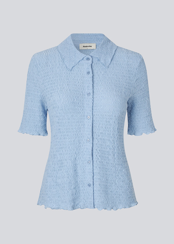 Kortærmet skjorte i lyseblå i et let og struktureret materiale. NolineMD shirt er figursyet og har en knappelukning fortil samt skjortekrave.