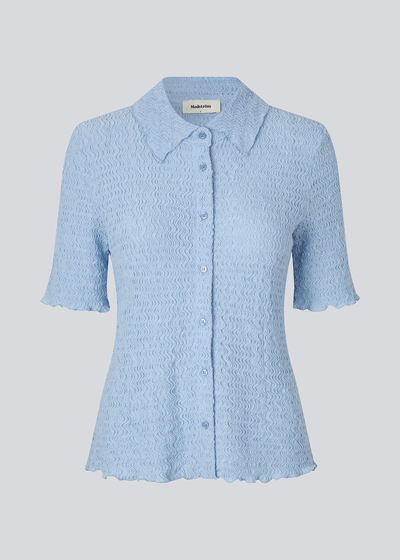 Kortærmet skjorte i lyseblå i et let og struktureret materiale. NolineMD shirt er figursyet og har en knappelukning fortil samt skjortekrave.