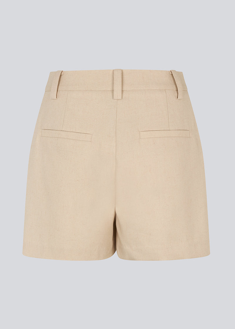 FShorts med høj talje og sidelommer i beige. NormaMD shorts har gylp med lynlås og knap, bæltestropper og dekorative paspolerede baglommer.