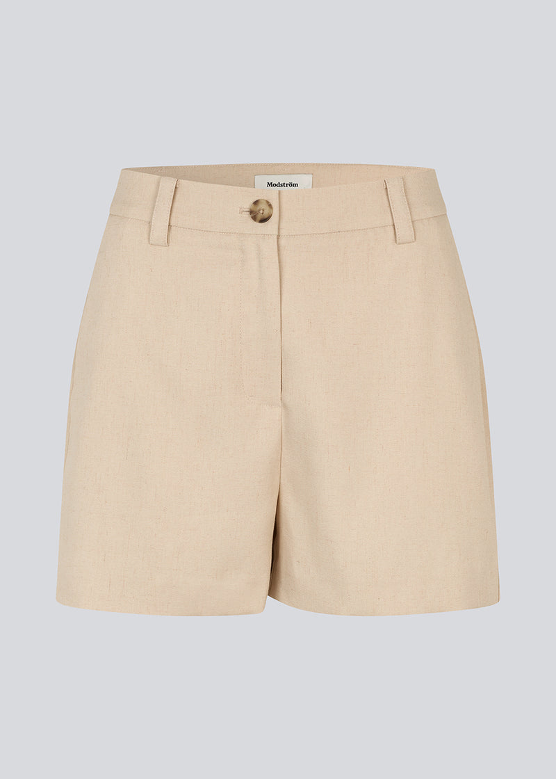 Shorts med høj talje og sidelommer i beige. NormaMD shorts har gylp med lynlås og knap, bæltestropper og dekorative paspolerede baglommer.