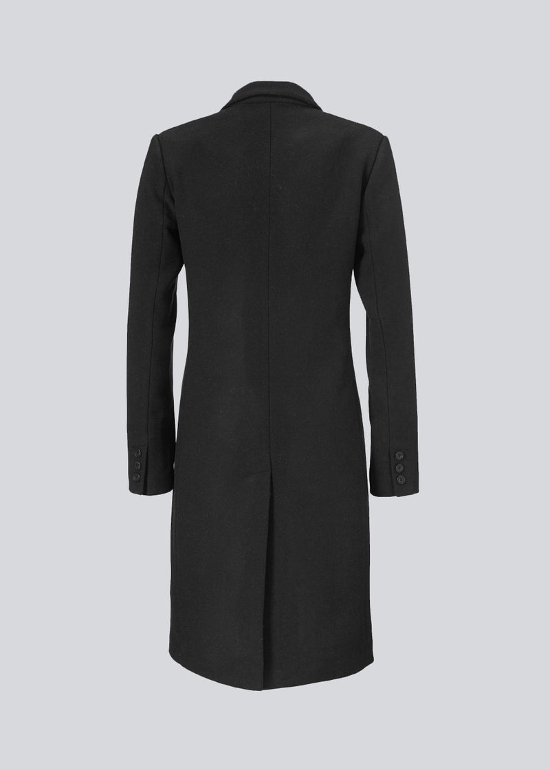 Smuk knælang uldfrakke i sort. Odelia coat bliver lukket fortil af fire knapper og er taljeret, hvilket giver et feminint udtryk. På grund af den høje kvalitet af uld, vil den være det oplagte valg til både efterår og de milde vintre.