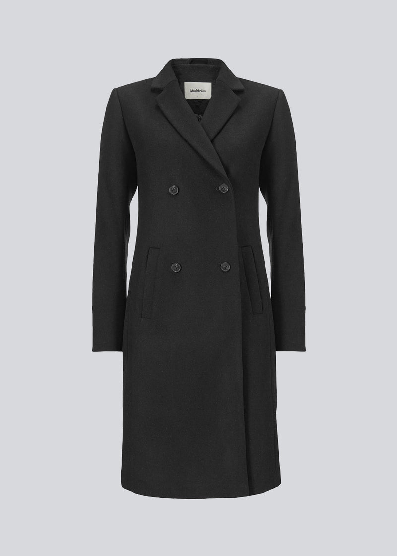 Smuk knælang uldfrakke i sort. Odelia coat bliver lukket fortil af fire knapper og er taljeret, hvilket giver et feminint udtryk. På grund af den høje kvalitet af uld, vil den være det oplagte valg til både efterår og de milde vintre.
