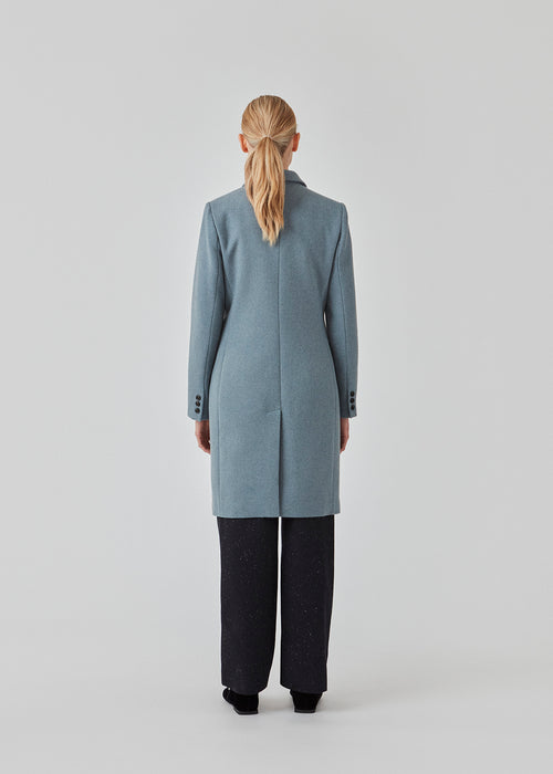 Smuk knælang uldfrakke. Odelia coat bliver lukket fortil af fire knapper og er taljeret, hvilket giver et feminint udtryk. På grund af den høje kvalitet af uld, vil den være det oplagte valg til både efterår og de milde vintre.