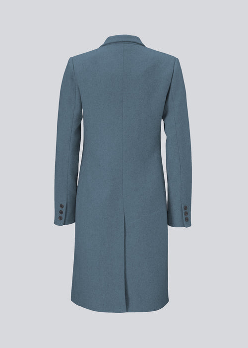 Smuk knælang uldfrakke. Odelia coat, i farven Blue Moon, bliver lukket fortil af fire knapper og er taljeret, hvilket giver et feminint udtryk. På grund af den høje kvalitet af uld, vil den være det oplagte valg til både efterår og de milde vintre.