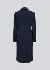 Smuk, lang uldfrakke i mørkeblå. Odelia long coat er dobbeltradet og taljeret, hvilket giver et feminint udtryk. Frakken er et oplagt valg til både efterår og de milde vintre.