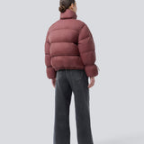 Rød dunjakke med høj hals i 100% genanvendt polyester. Odinmd jacket har en lynlåslukning og en justerbar elastik i ærmet. Modellen er 175 cm og har en str. s/36 på.