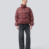 Rød dunjakke med høj hals i 100% genanvendt polyester. Odinmd jacket har en lynlåslukning og en justerbar elastik i ærmet. Modellen er 175 cm og har en str. s/36 på.