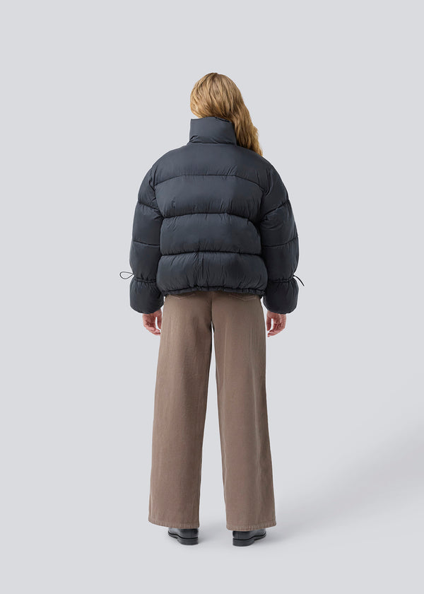 Sort dunjakke med høj hals i 100% genanvendt polyester. Odinmd jacket har en lynlåslukning og en justerbar elastik i ærmet. Modellen er 175 cm og har en str. s/36 på.
